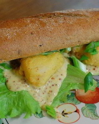 Сэндвич с рыбой в кляре и листьями салата